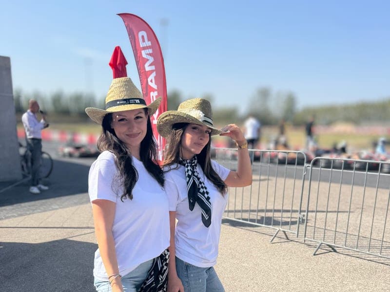 Két hostess szalmakalapban egy szabadtéri roadshow helyszínén